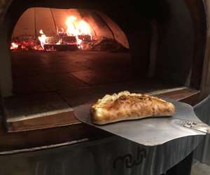 calzone going into the wood fired oven