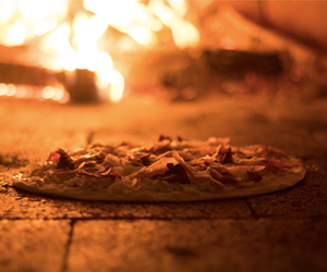 pizza cooking in wood fired oven