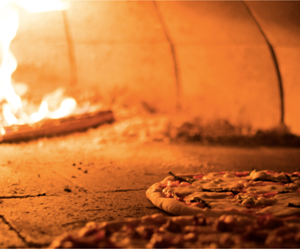 pizza cooking in wood fired oven