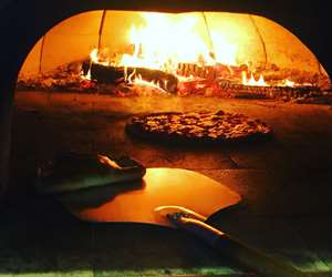 pizza cooking in wood fired oven